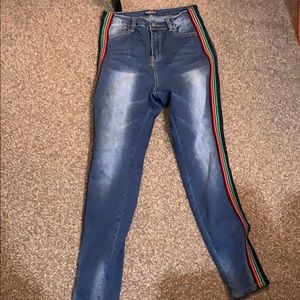 Denim jeans with red,green,and black stripes.